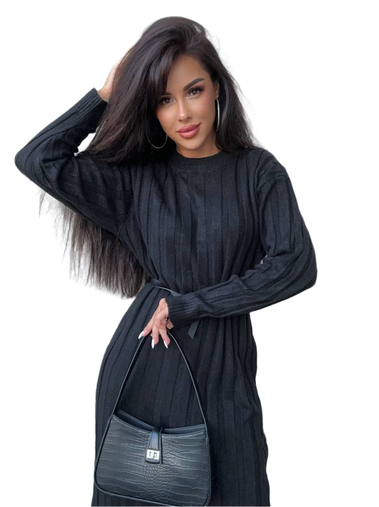 Woman wearing a black dress holding a matching handbag on a white background