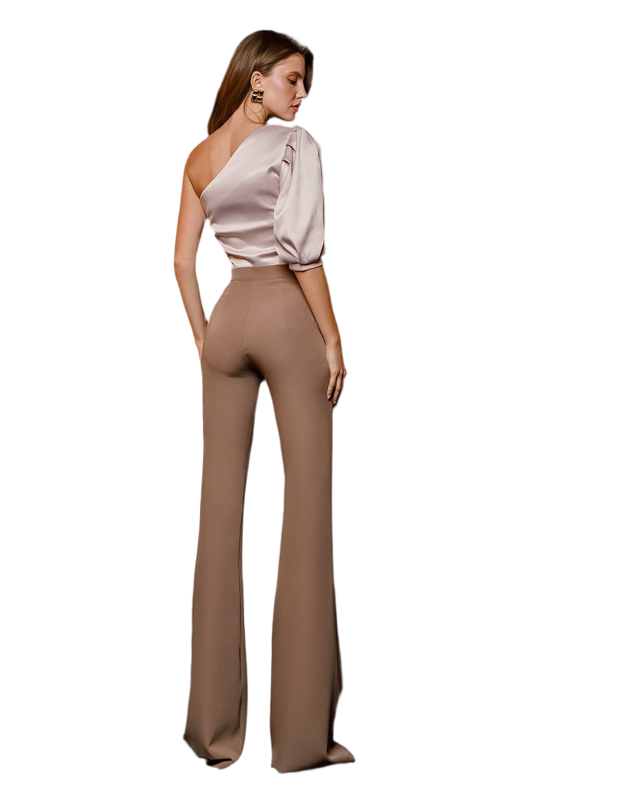 Woman wearing a one-shoulder top and high-waisted pants on a white background