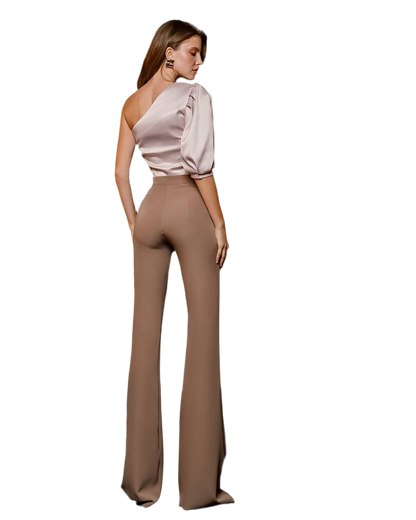 Woman wearing a one-shoulder top and high-waisted pants on a white background