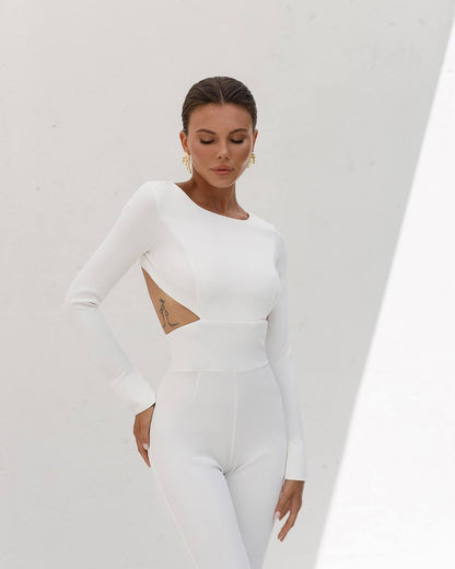 Woman wearing a white long-sleeve dress with cut-out design on a white background