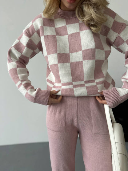 Person wearing a pink and white checkered sweater and matching pants.