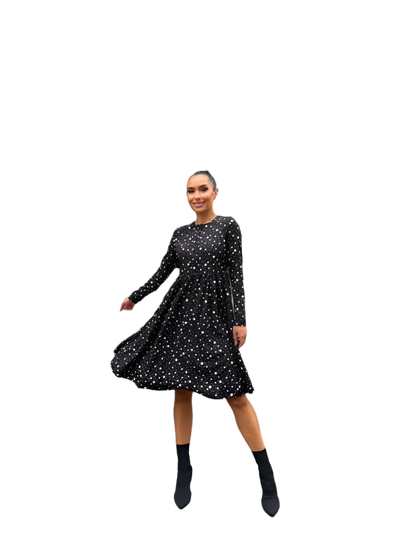 Woman wearing a black dress with white polka dots on a white background