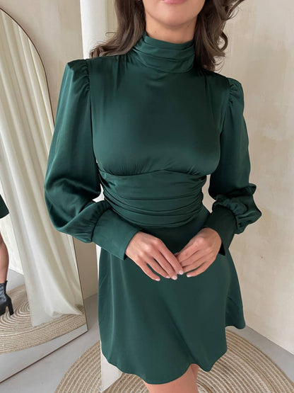 Woman wearing a green dress with long sleeves in an indoor setting