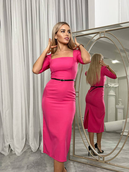 Woman in a bright pink dress standing in front of a mirror.