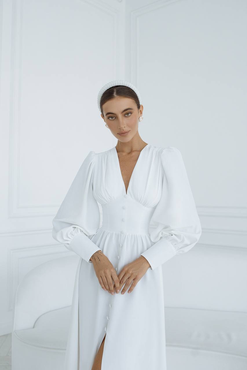 Woman wearing a white dress with a plain background