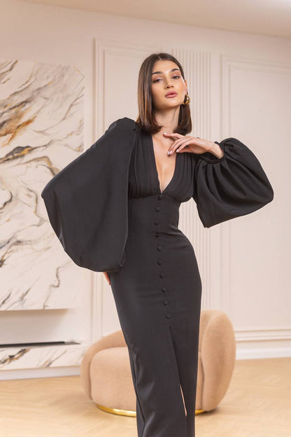 Woman wearing a black outfit with puffed sleeves in an elegant room.