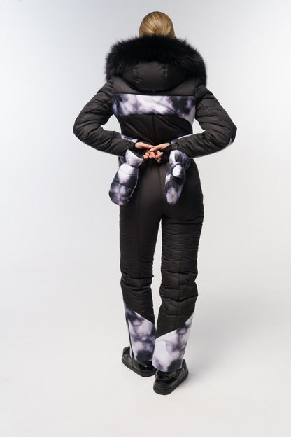 Person wearing a black puffer suit with fur hood on a white background