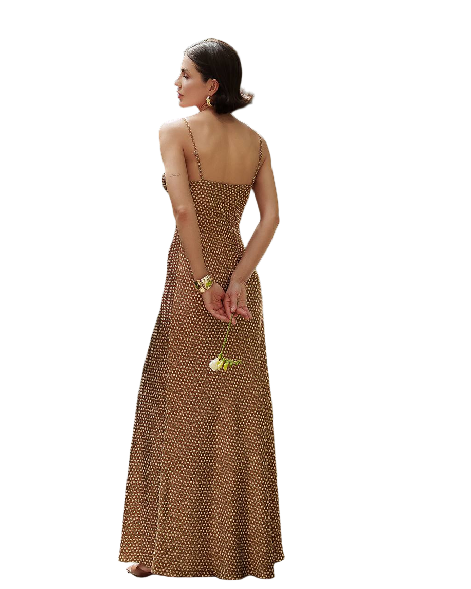 Woman wearing a brown polka dot dress holding a yellow flower on a white background