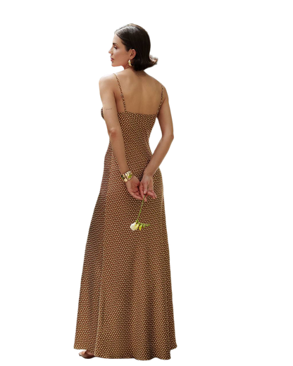 Woman wearing a brown polka dot dress holding a yellow flower on a white background