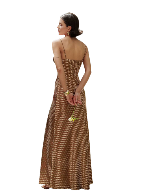 Woman wearing a brown polka dot dress holding a yellow flower on a white background