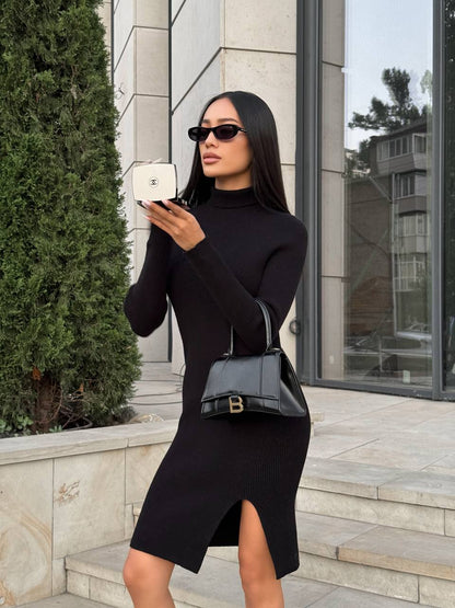 Woman in a black dress holding a white handbag and a black handbag outdoors.