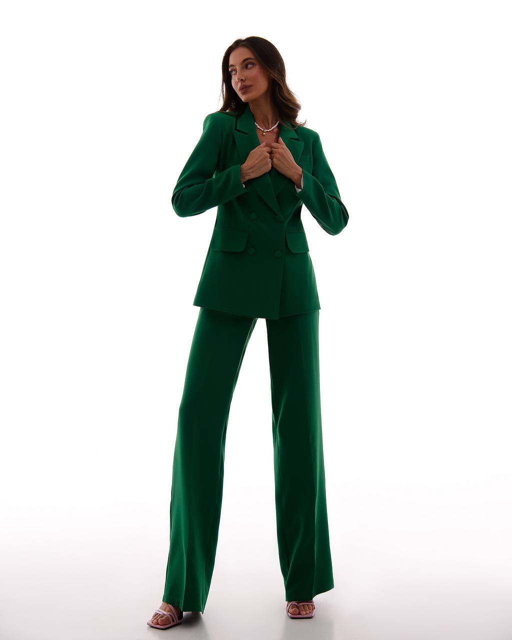 Woman wearing a green suit on a white background