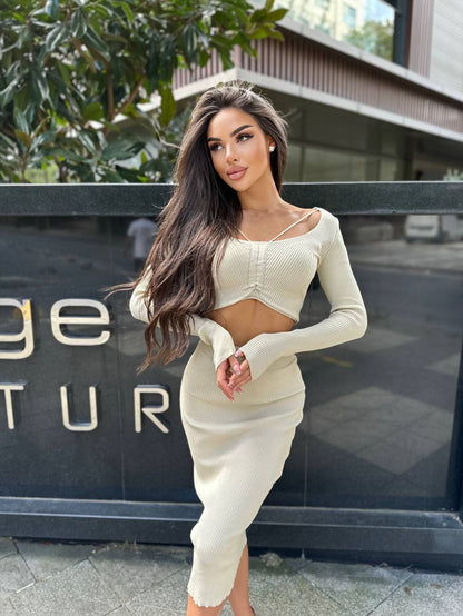 Woman in a white outfit standing in front of a building with 'Ritz Carlton' branding.