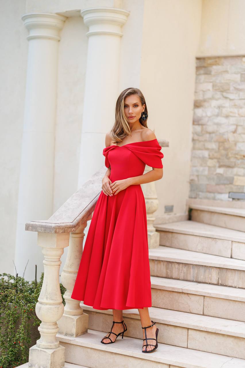 Woman in a red off-shoulder dress standing on stone steps with classical architecture in the background