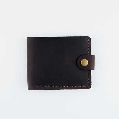 A dark brown leather bifold wallet with a snap-button closure, shown flat against a plain white background.