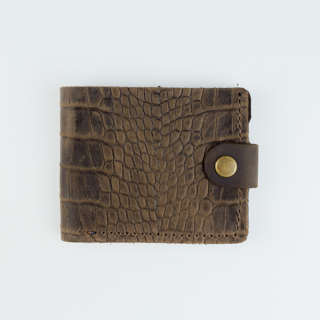 A brown leather bi-fold wallet with a crocodile-embossed texture and a snap-button closure, shown flat against a plain white background.