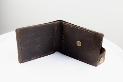 A dark brown leather bifold wallet shown open, displaying its interior card slots, stitching, and brass snap buttons, set against a clean white background.