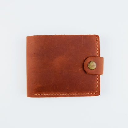 A brown leather bifold wallet with a snap-button closure, shown closed on a plain white background.