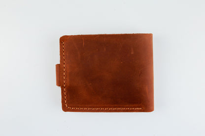 A brown leather bifold wallet with visible stitching and a small side tab, photographed flat against a plain white background.