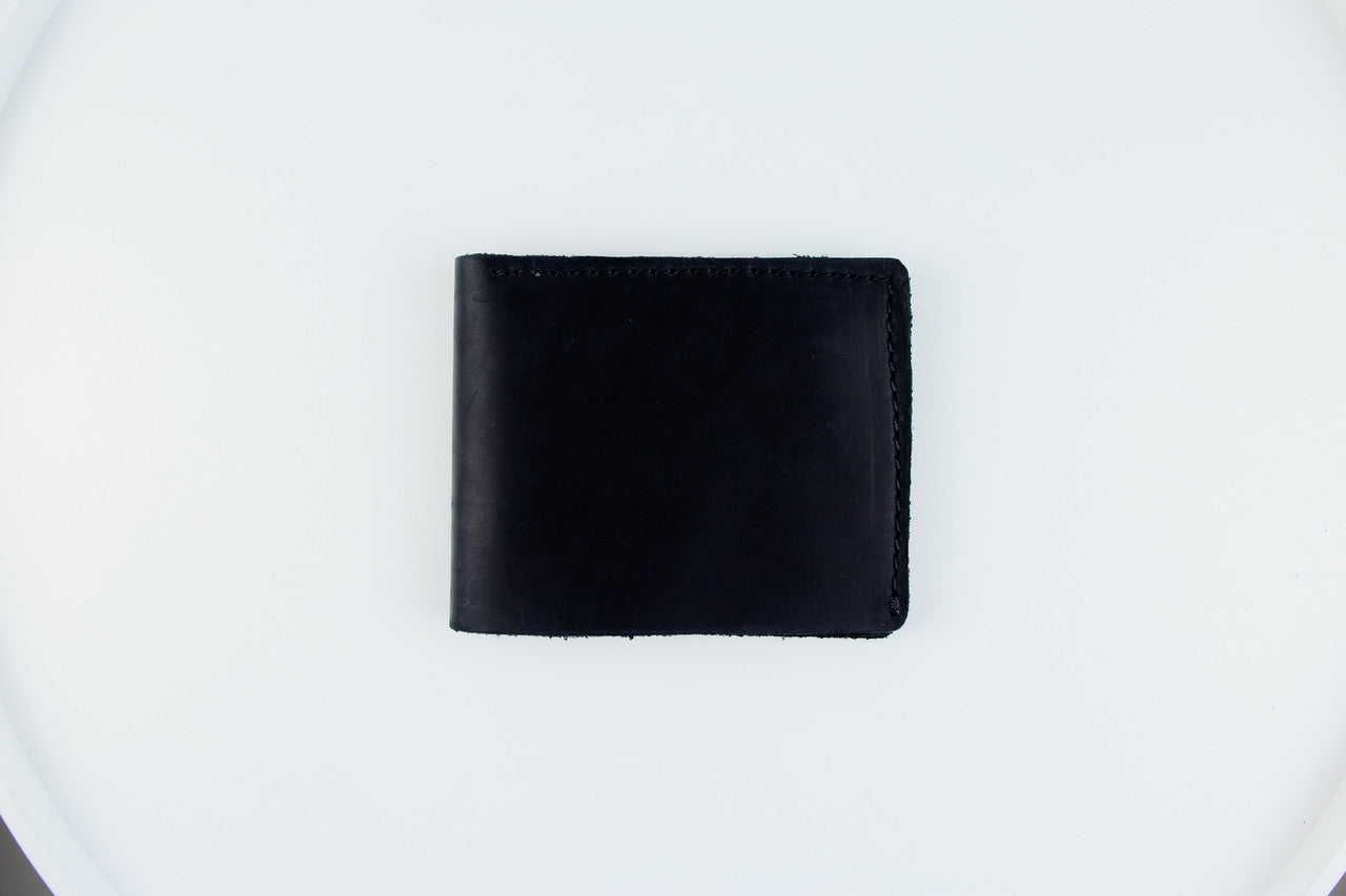 A black leather bi-fold wallet centered on a plain white background.