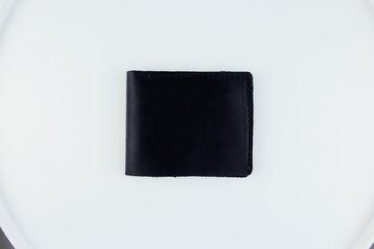 A black leather bi-fold wallet centered on a plain white background.