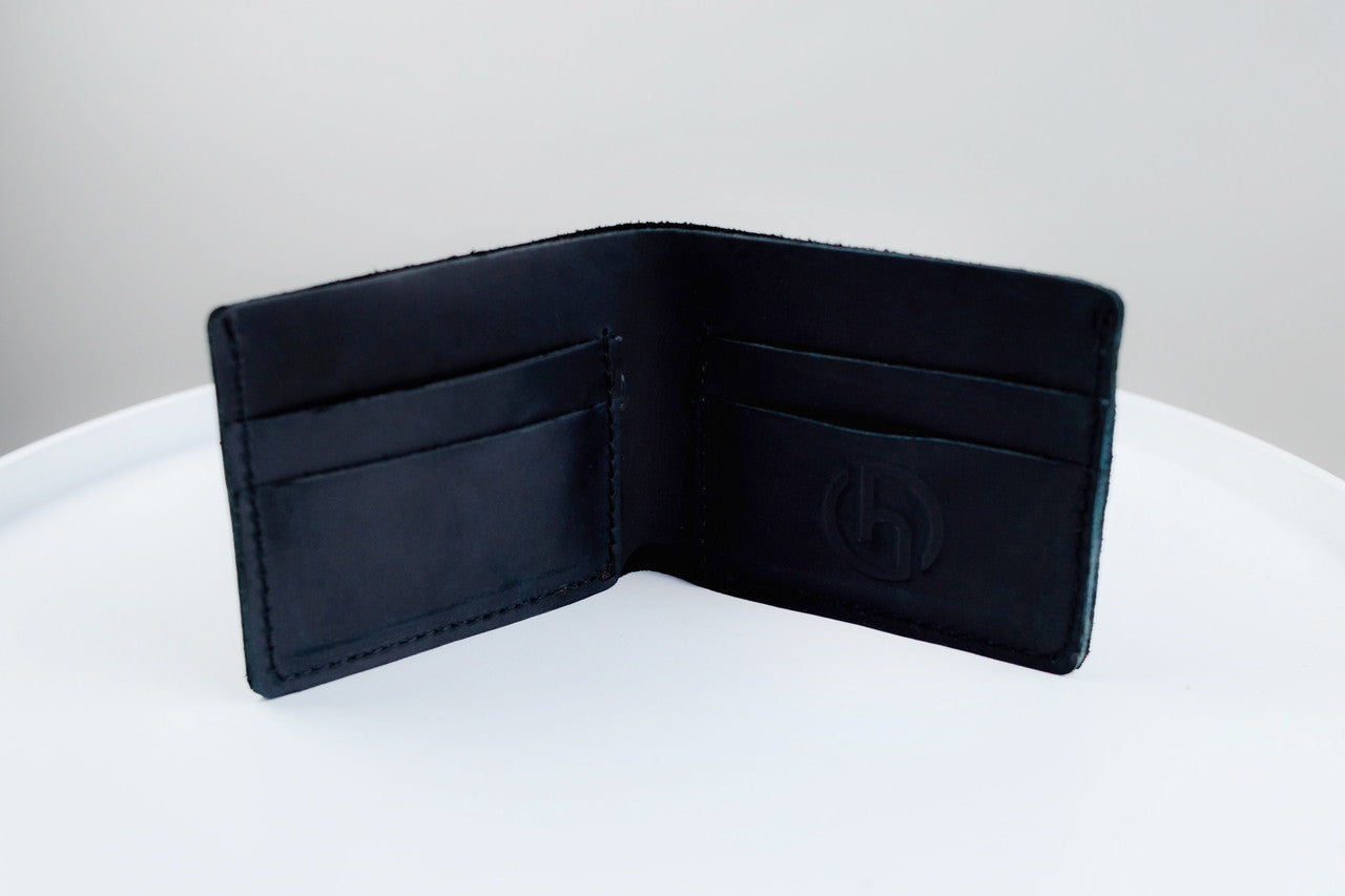 An open black leather bifold wallet with multiple card slots and a debossed logo on the inside, displayed on a white surface against a light gray background.