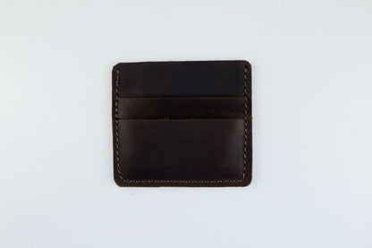 A dark brown leather card holder wallet with visible stitching, photographed flat against a plain white background.
