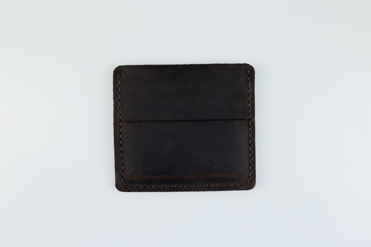 A dark brown leather card holder wallet with visible contrast stitching, photographed flat against a clean white background.