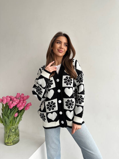 Woman wearing a black and white patterned cardigan with pink tulips on a light background