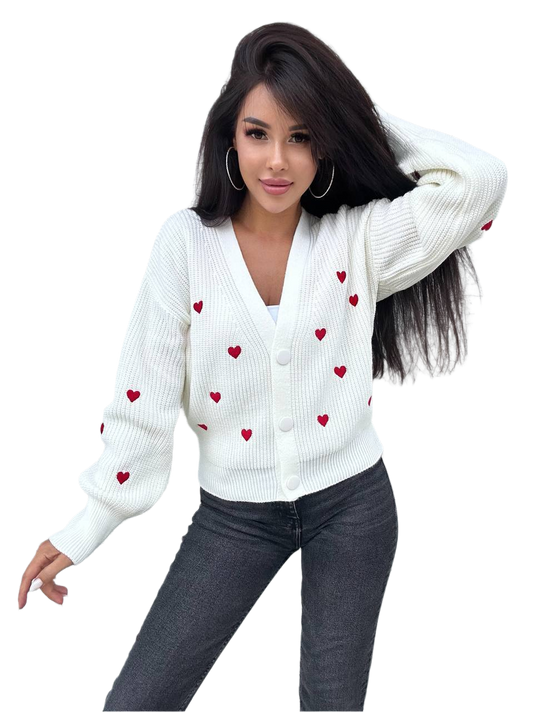 Woman wearing a white cardigan with red heart patterns on a white background