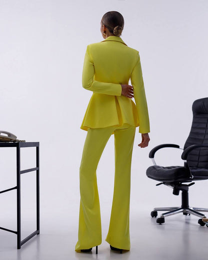 Person wearing a bright yellow suit standing in an office setting with a chair and desk.