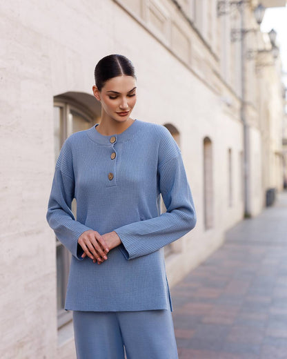 Woman wearing a blue outfit standing on a street with a building in the background