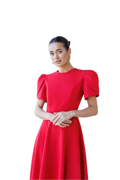 Woman wearing a red dress with puff sleeves on a white background