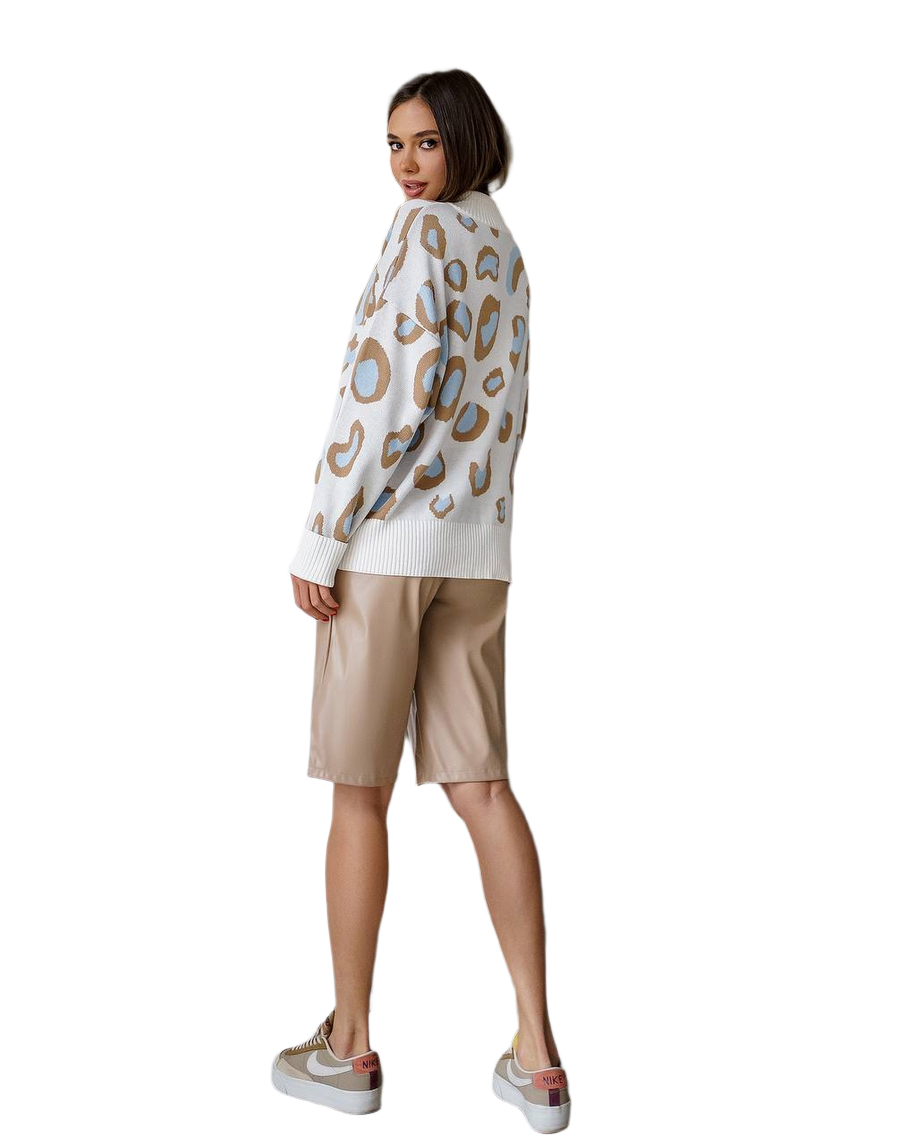 Woman wearing a patterned sweater and beige shorts on a white background
