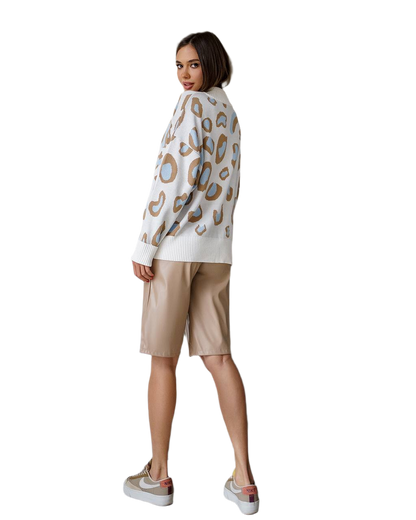 Woman wearing a patterned sweater and beige shorts on a white background