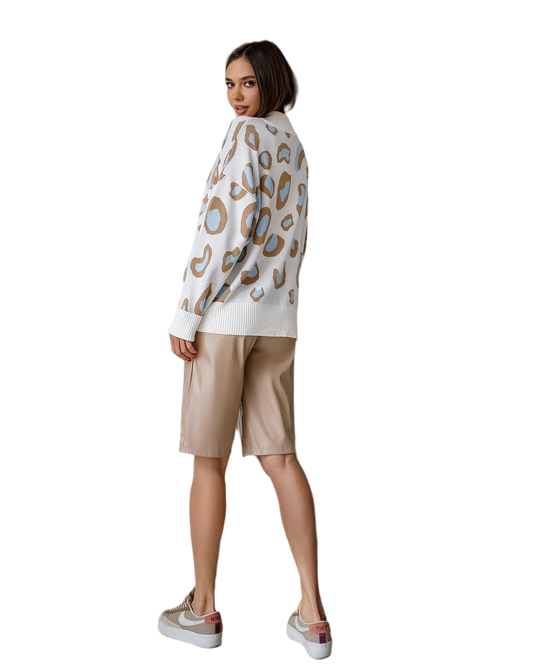 Woman wearing a patterned sweater and beige shorts on a white background
