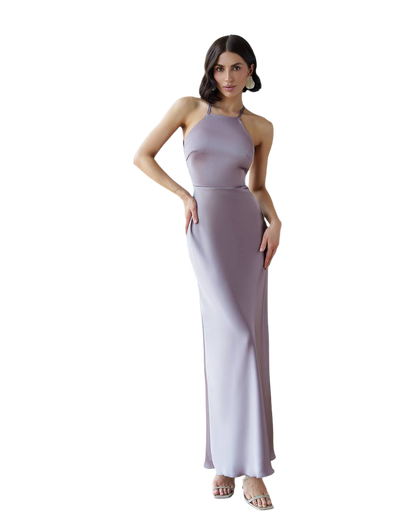 Woman wearing a long, halter-neck dress with a gradient effect on a white background