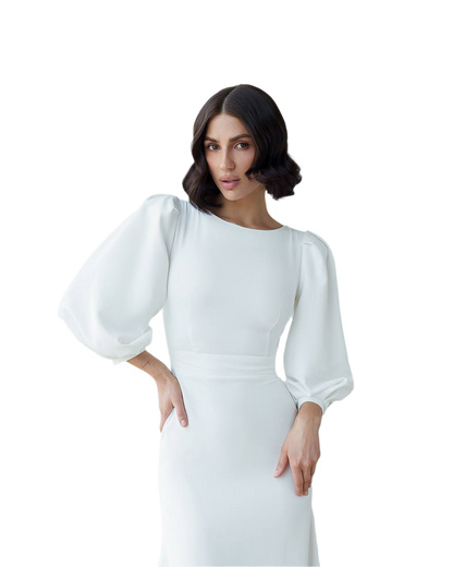Woman wearing a white dress with puffed sleeves on a white background