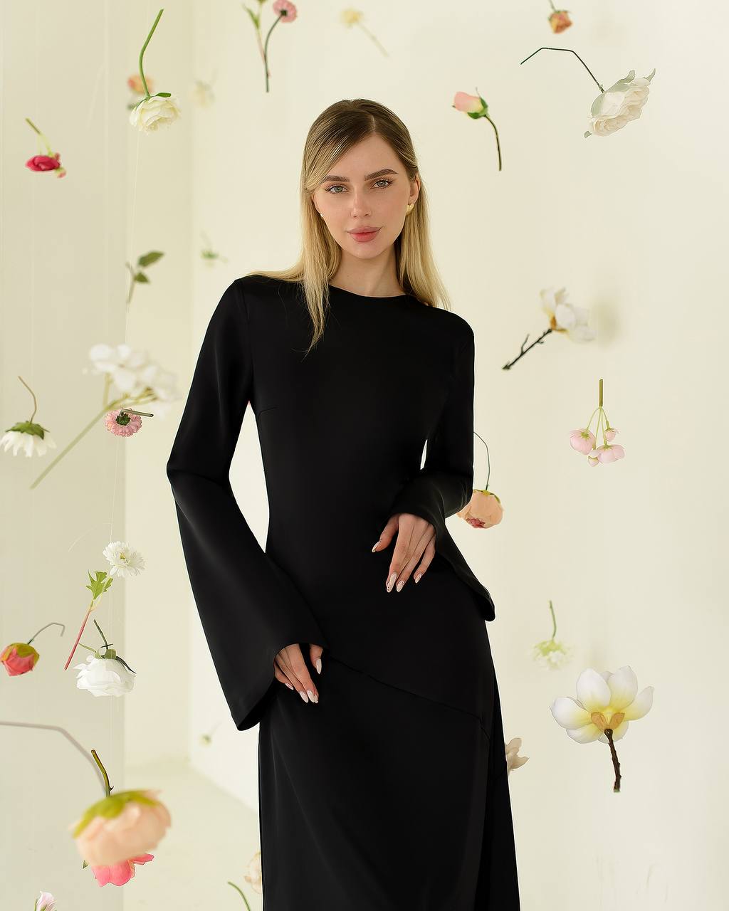 Woman wearing a black dress against a floral background