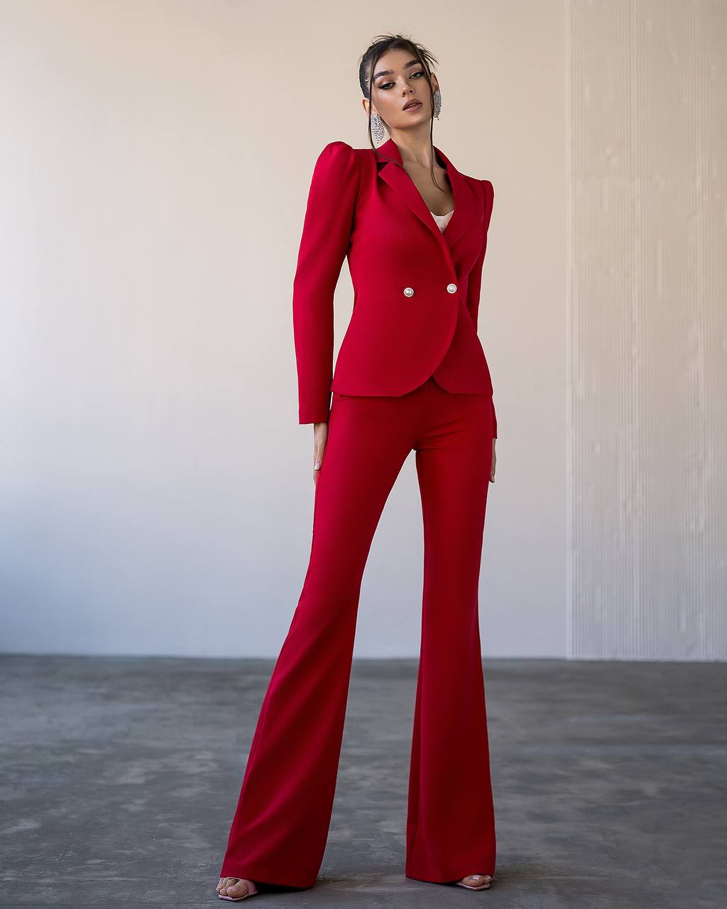 Woman wearing a red suit against a plain background