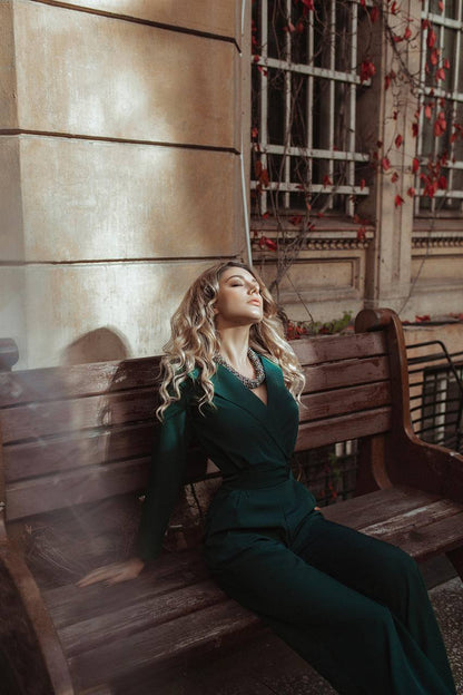 Woman in a green suit sitting on a wooden bench with a warm, vintage-style background.