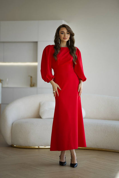 Woman in a red dress standing in a modern interior setting