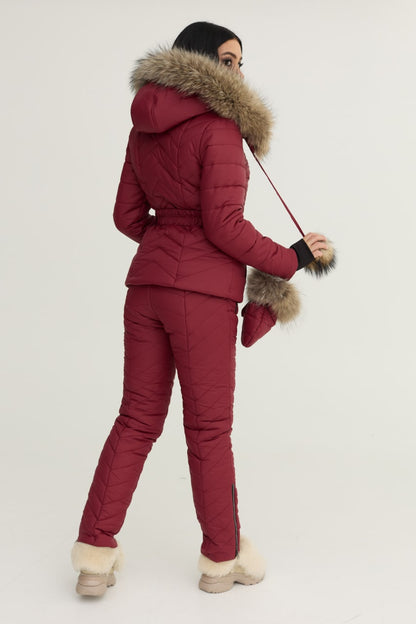Person wearing a red winter outfit with fur-lined hood and cuffs on a white background