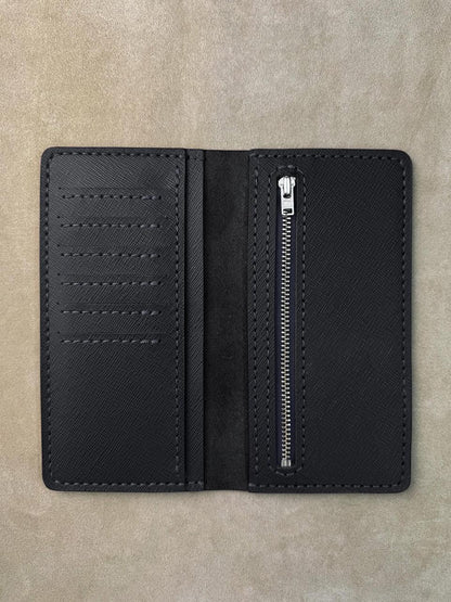 A black textured leather wallet shown open, featuring multiple card slots on the left and a vertical zippered pocket on the right, photographed flat on a neutral beige textured background.