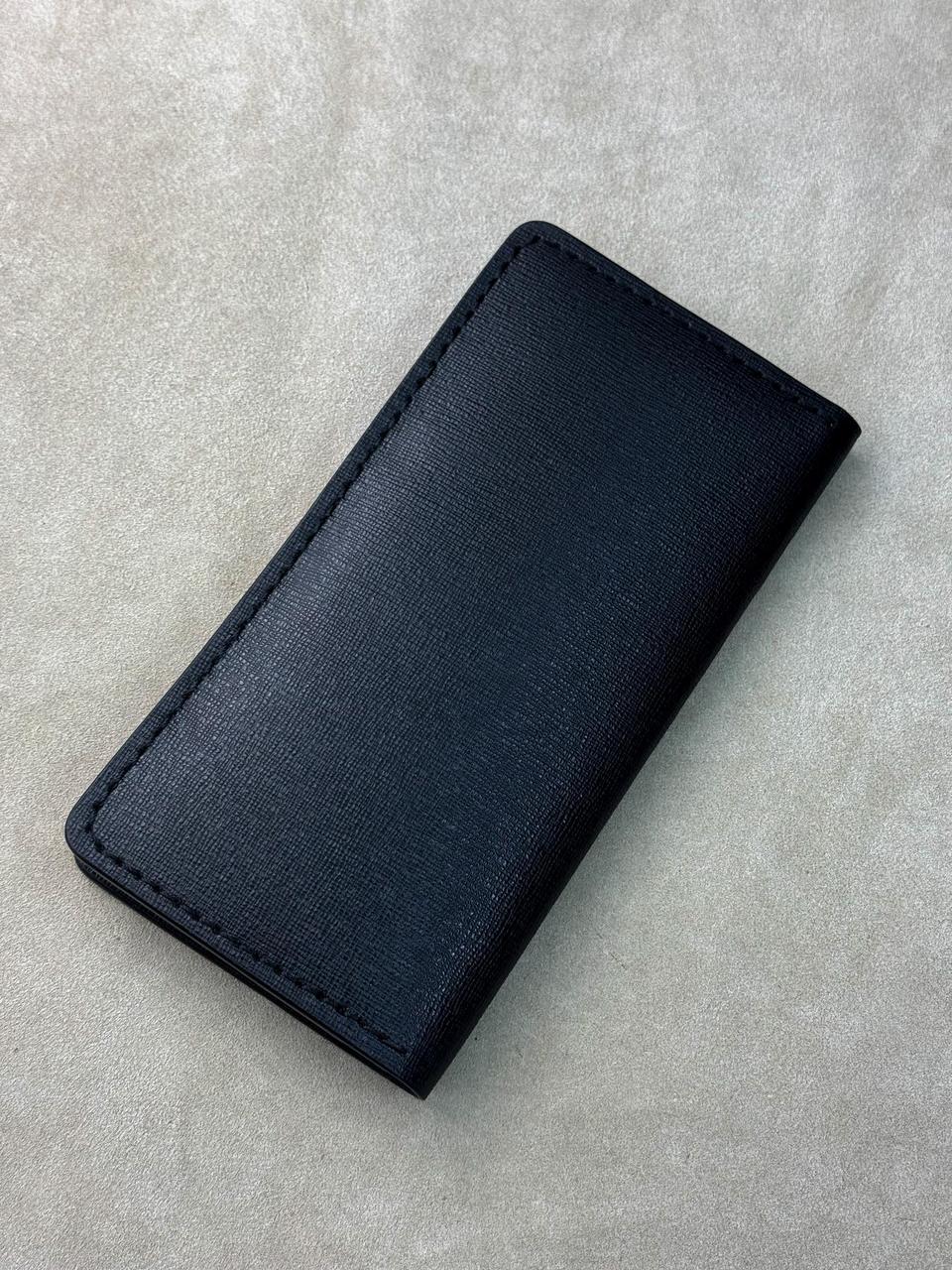 A dark navy blue textured leather card holder or wallet, shown closed on a light gray textured background.