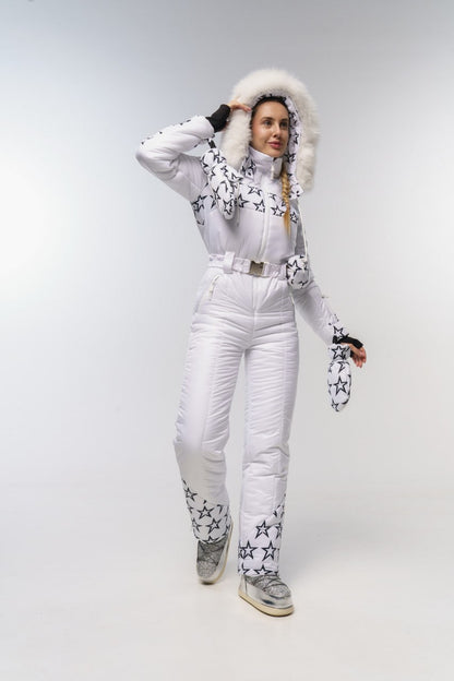Person wearing a white snowsuit with star patterns on a plain background