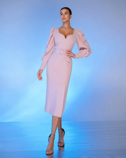 Woman wearing a light pink dress with puffed sleeves against a gradient blue background