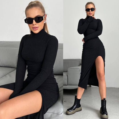 Woman wearing a black dress with a high slit, sitting on a gray couch.