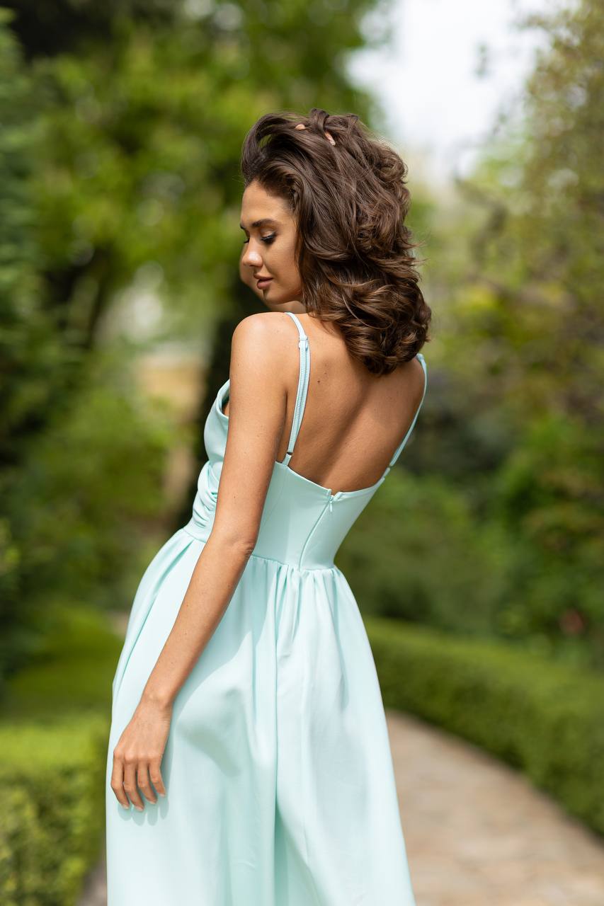 Woman in a light blue dress standing in a garden