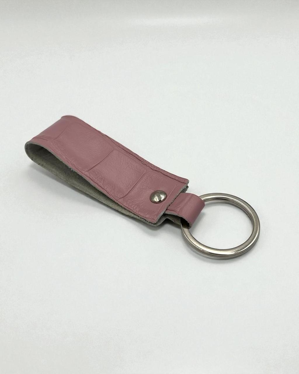 A rose pink leather keychain holder with a silver metal split ring, shown on a light gray background.